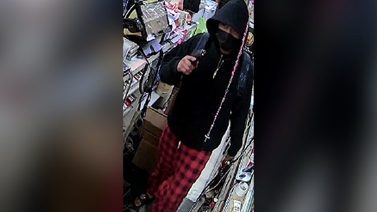 armed man in black hoodie at convenience store