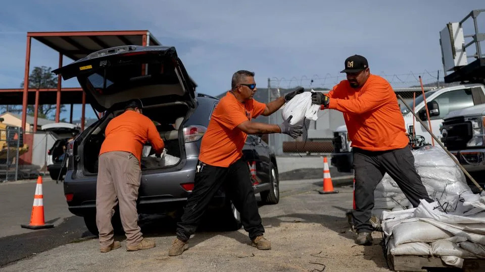 Workers with the Los Angeles County Public Works Department distribute sandbags to residents in Altadena, California, on Monday. - Eric Thayer/Los Angeles Times/Getty Images