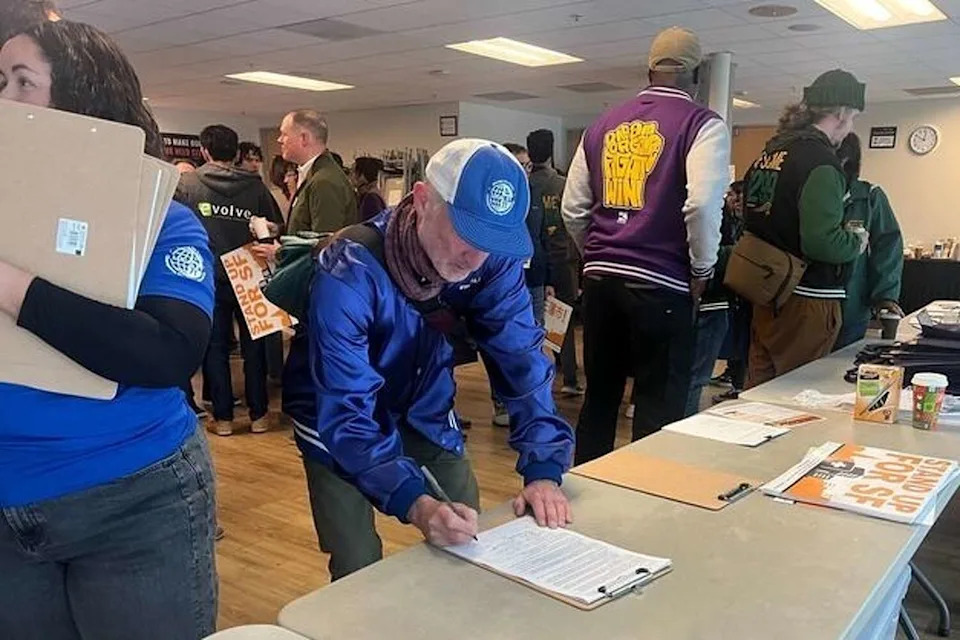 Signatures are collected Saturday to put the Overpaid CEO Act on the San Francisco ballot. (St. John Barned-Smith/S.F. Chronicle)