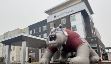 a four-story hotel building with a large inflatable bulldog in front of it
