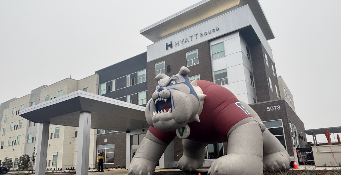 a four-story hotel building with a large inflatable bulldog in front of it