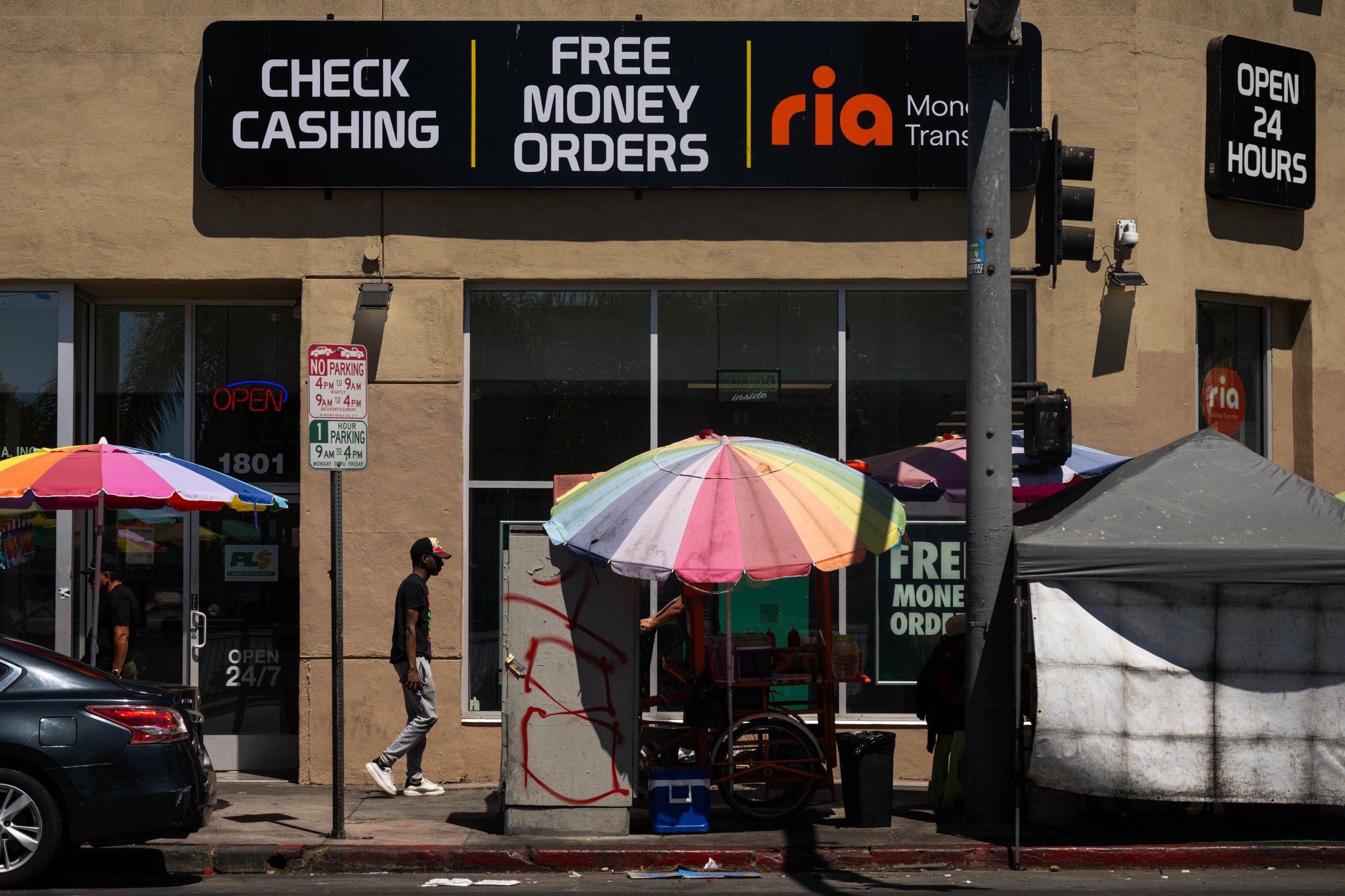 A man passes street vendors in Westlake on September 8, 2025.