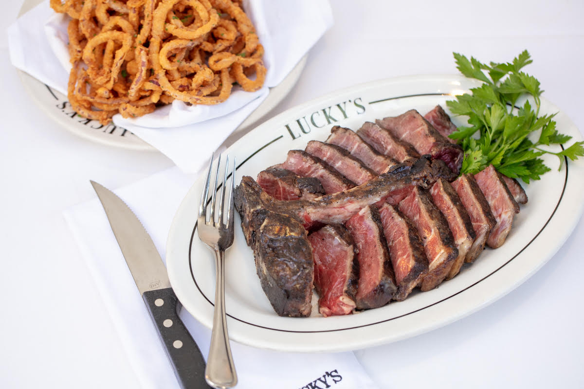 A white table shows a filet of steak next to a sharp knife.