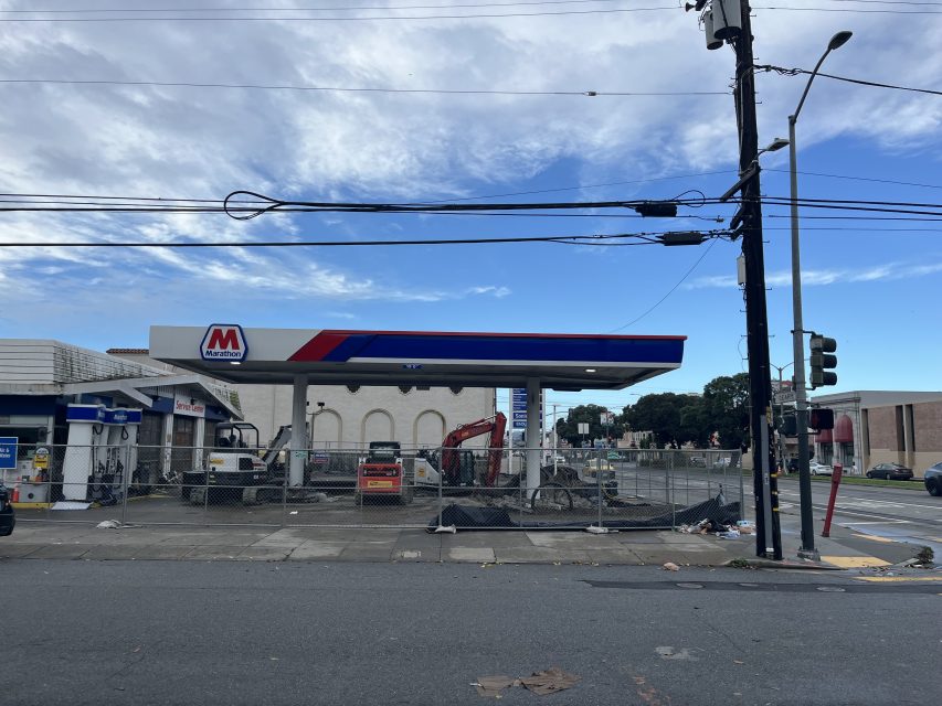 A Marathon gas station under construction, with equipment and fencing blocking access, viewed from across the street on a cloudy day.