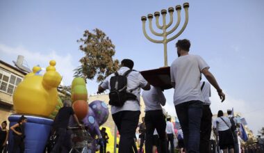 In this Oct. 17, 2019 file photo, people carry a Menorah as they participate in an annual support march for Israel. (AP Photo/Oded Balilty)