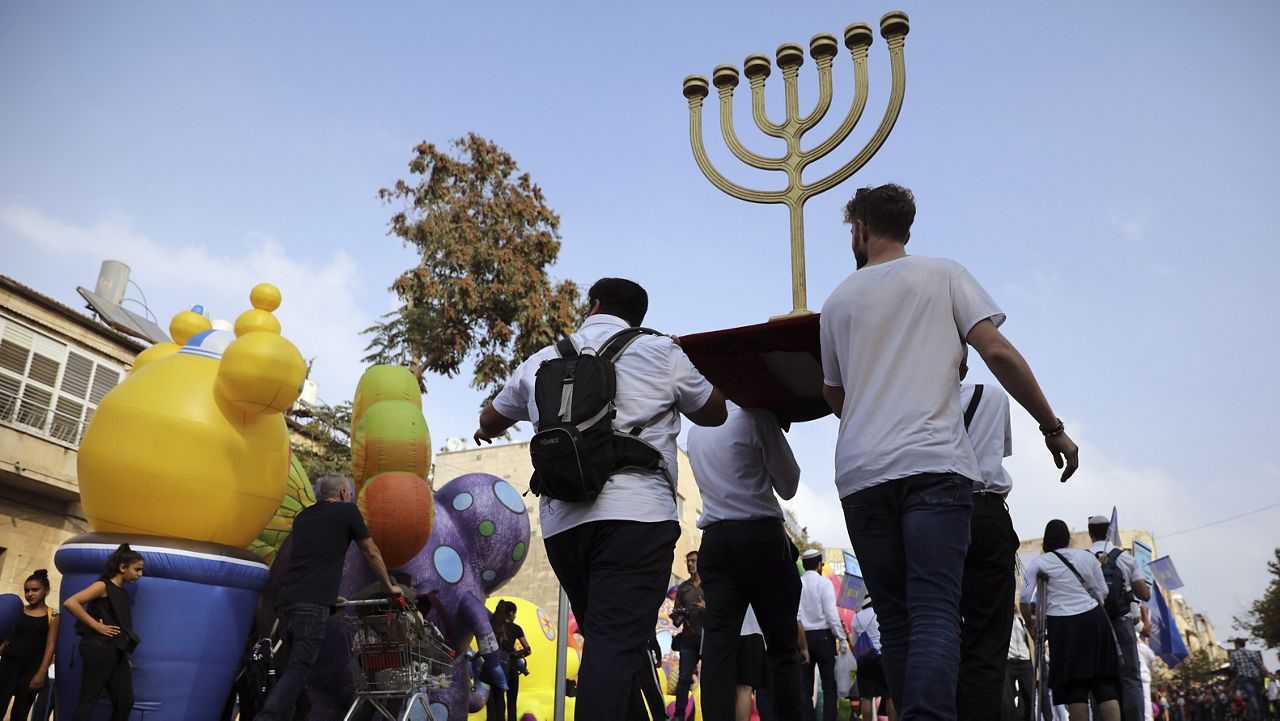In this Oct. 17, 2019 file photo, people carry a Menorah as they participate in an annual support march for Israel. (AP Photo/Oded Balilty)