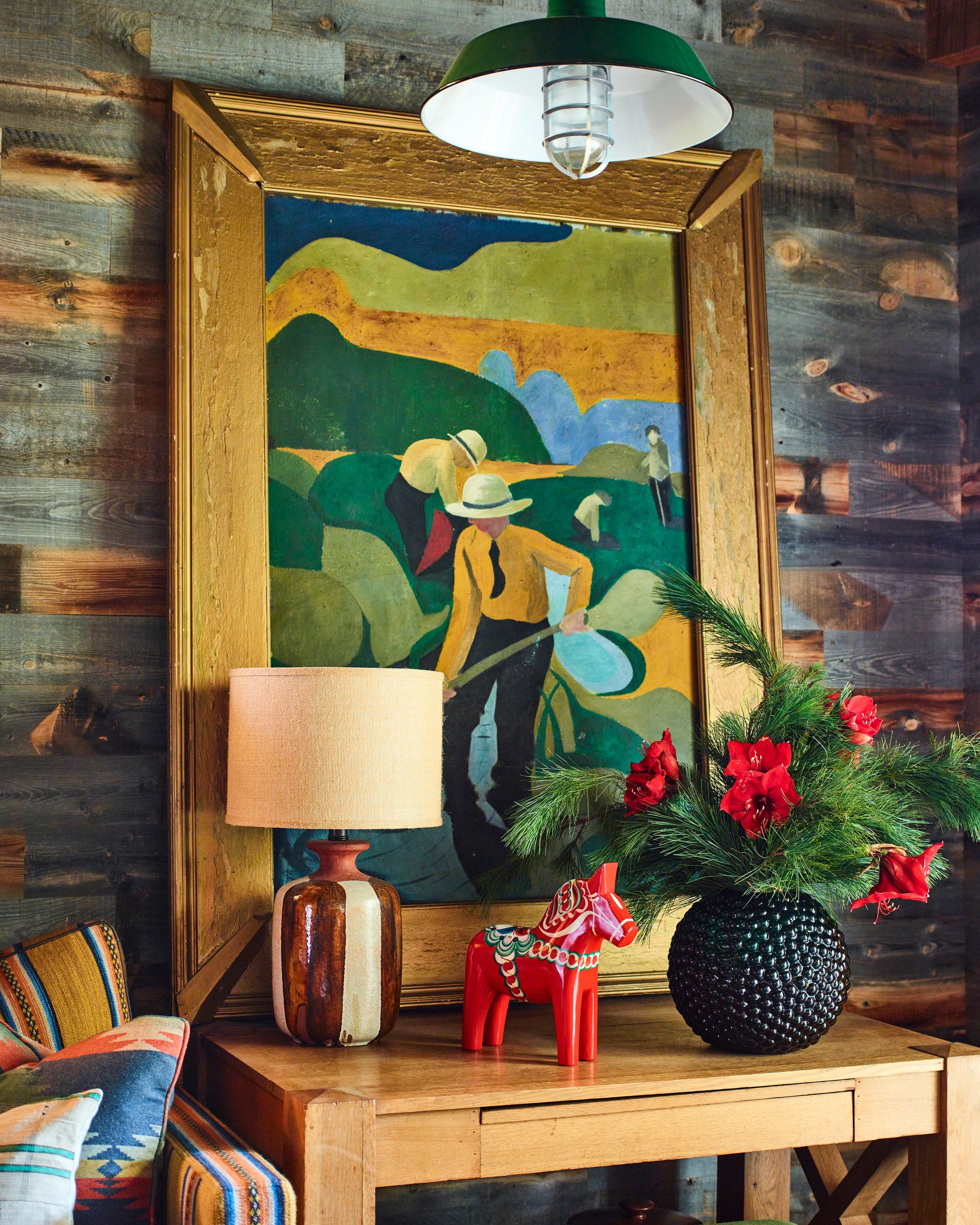 framed colorful painting on a wood table against a wood paneled wall