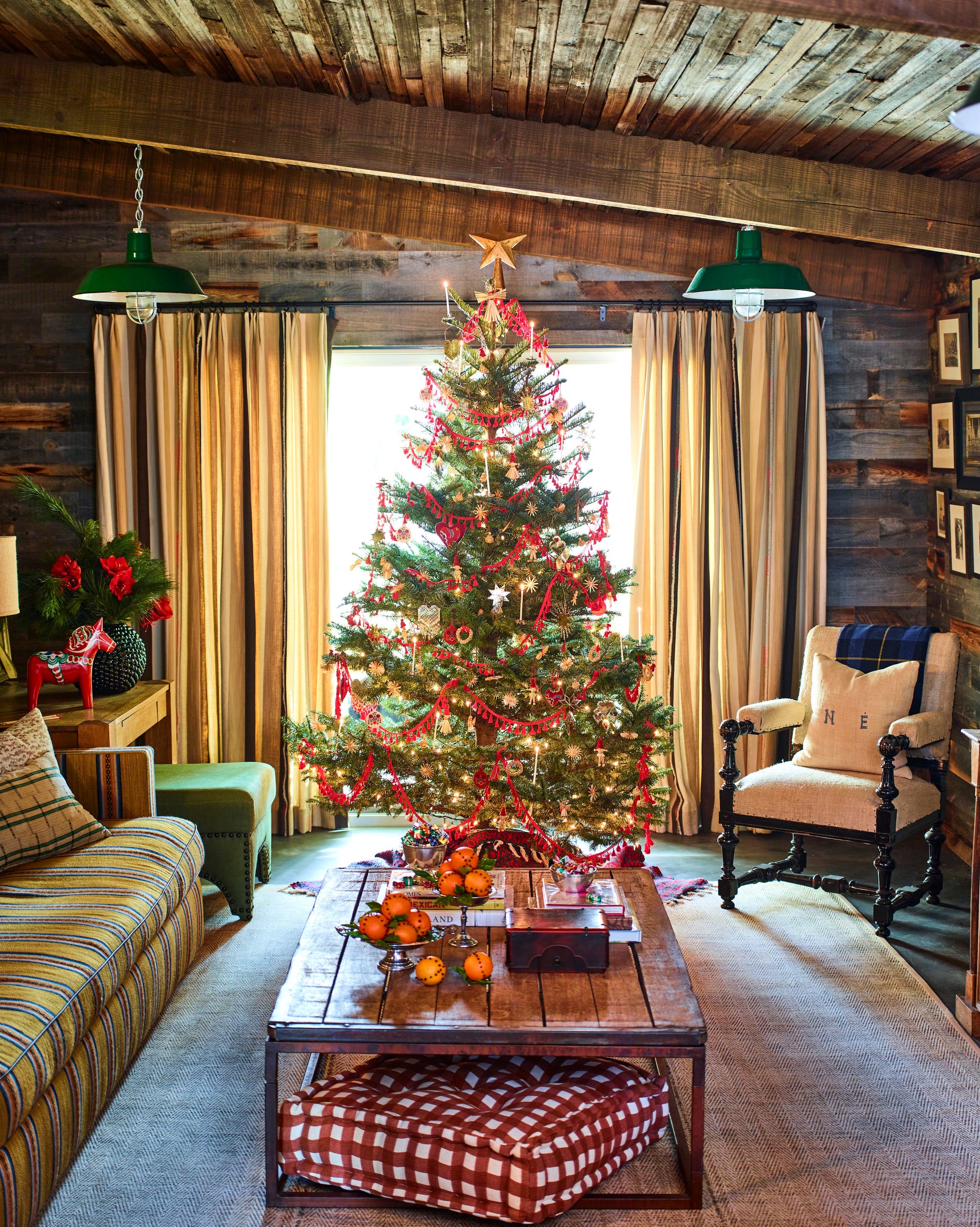 decorated christmas tree in front of a living room by a couch and coffee table