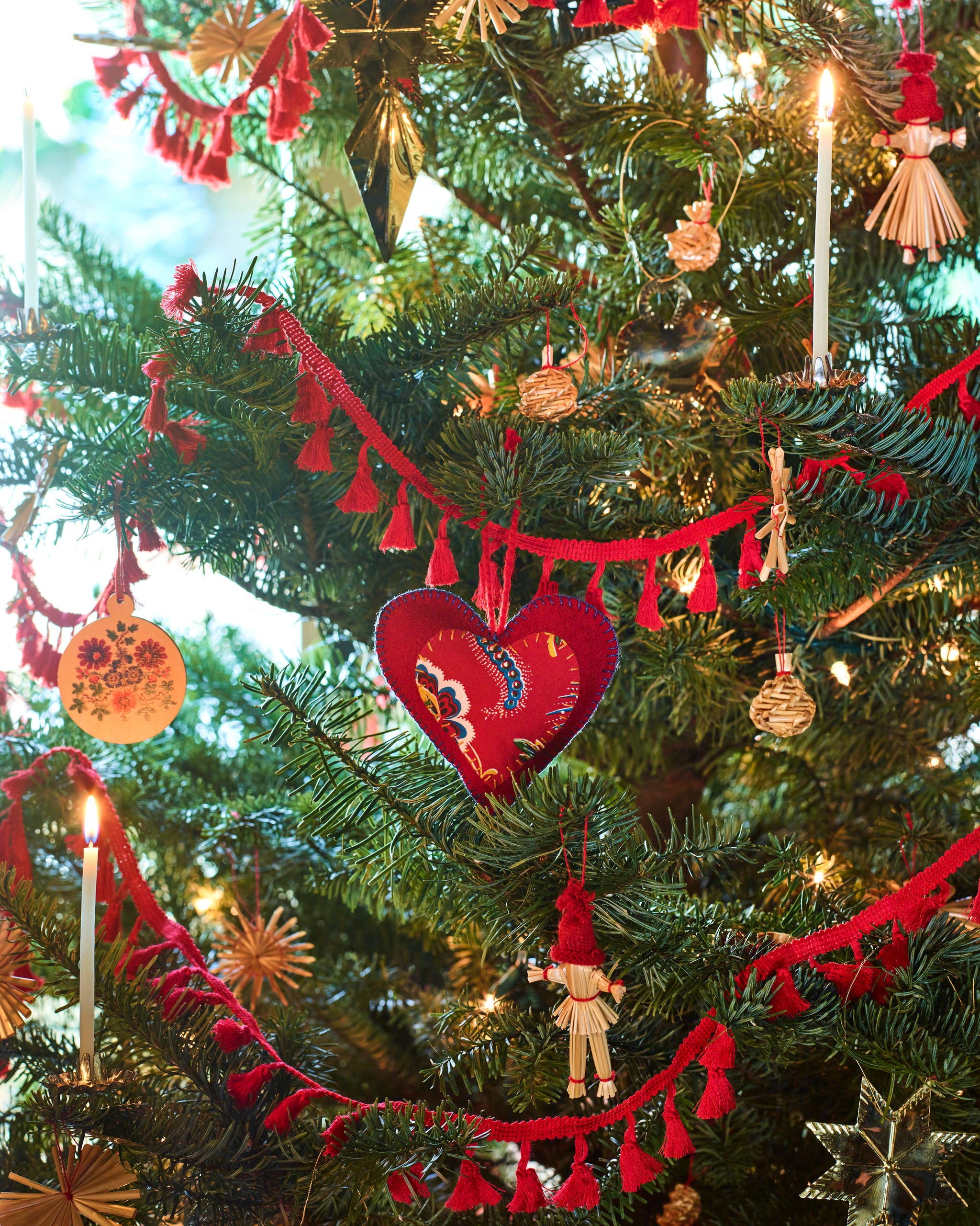 closeup of christmas tree with red garland and various ornnaments