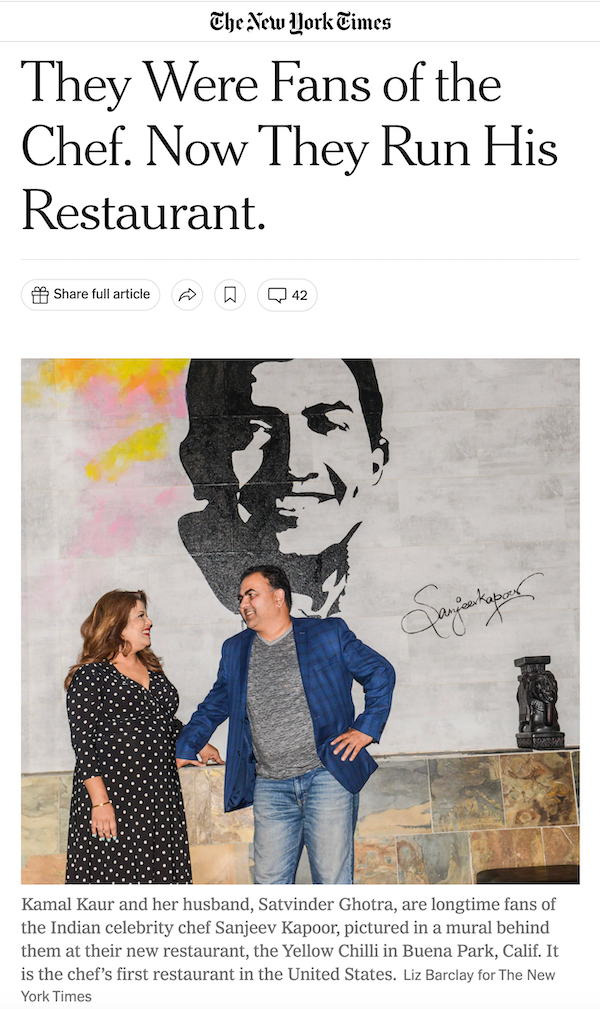 online article with two people standing in front of amural of a man