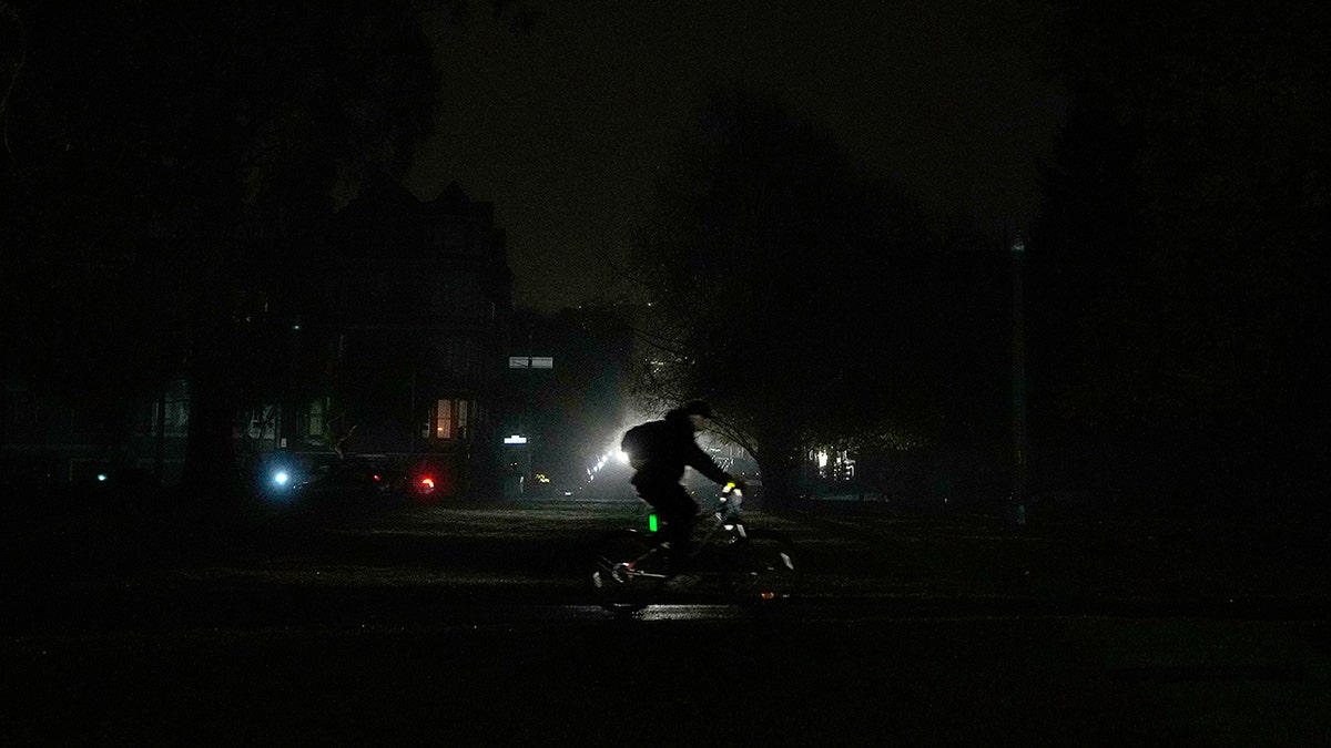 bicyclist rides on darkened streets