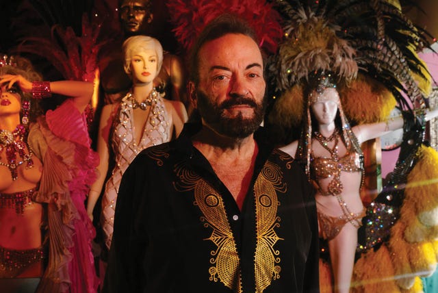 grant philipo stands inside his las vegas home turned museum, surrounded by showgirl mannequins in feathered headdresses and jeweled gowns.
