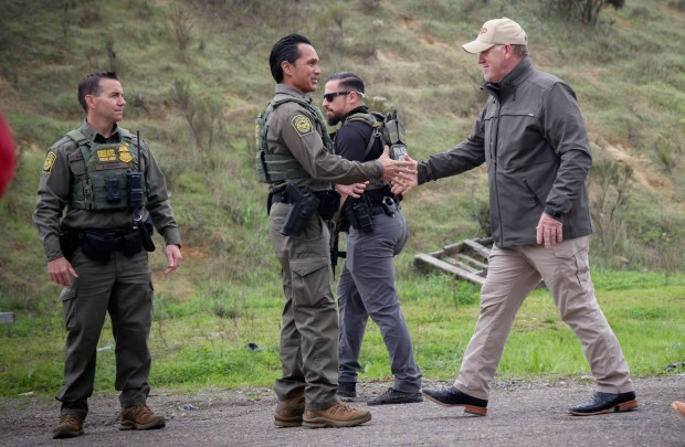 White House "border czar" Tom Homan shakes hands with Border Patrol agents after a press conference along the U.S.-Mexico border wall in San Ysidro on Saturday. (Sandy Huffaker / For The San Diego Union-Tribune)