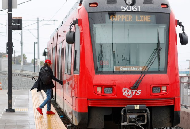 El Cajon, CA - December 23: A passenger boards a MTS Trolley on the Copper Line at the El Cajon Station before departing to Santee on December 23, 2025 in El Cajon, CA. (K.C. Alfred / The San Diego Union-Tribune)