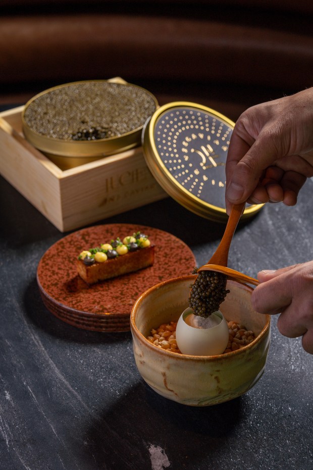 The first course at Lucien restaurant in La Jolla is something chef/co-owner Elijah Arizmendi calls the "egg royale," where egg dashi custard is topped with chantilly cream and served inside the egg's own shell, then topped tableside with N25 Osetra caviar. It's served with a slice of banana buckwheat toast. (Kimberly Motos)