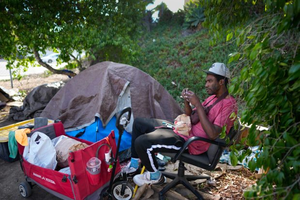 Lemon Grove, CA - November 13: Dalen Harrison, 30, gets his breakfast at his encampment in Lemon Grove. Harrison is scheduled to go back looking at various transitional apartments with outreach workers and housing coordinators. (Nelvin C. Cepeda / The San Diego Union-Tribune)