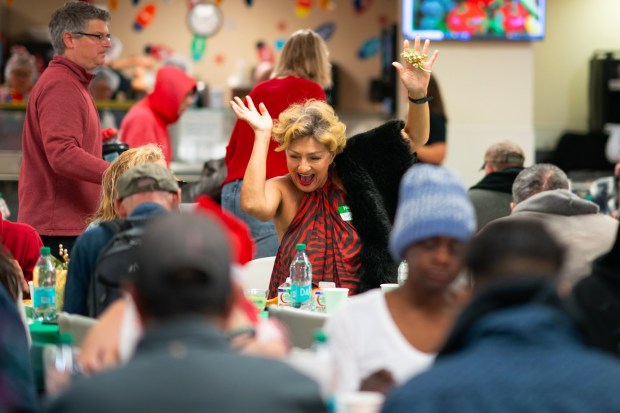 Sylvie Campa, 65 danced in her chair while enjoying her Christmas meal and live music at the San Diego Rescue Mission. An estimated 900 folks enjoyed a warm Christmas meal at the San Diego Rescue Mission on Saturday, Dec. 20, 2025, in San Diego, CA.   (Nelvin C. Cepeda / The San Diego Union-Tribune)