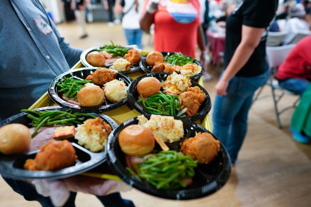 San Diego, CA - December 20: Volunteers served warm dinner entrees that included ham, mashed potatoes, green beans, chicken, and a bread roll to each guest in the dining room. An estimated 900 people enjoyed a warm Christmas meal at the San Diego Rescue Mission on Saturday, December 20, 2025, in San Diego, CA.  (Nelvin C. Cepeda / The San Diego Union-Tribune)