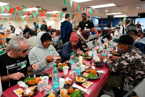 San Diego, CA - December 20: Volunteers served warm dinner entrees that included ham, mashed potatoes, green beans, chicken, and a bread roll to each guest in the dining room. An estimated 900 people enjoyed a warm Christmas meal at the San Diego Rescue Mission on Saturday, December 20, 2025, in San Diego, CA.  (Nelvin C. Cepeda / The San Diego Union-Tribune)