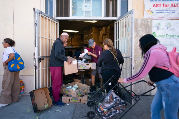 Volunteers help distribute the food to the public at the Somali Bantu Association of America in City Heights on Dec. 11. (Nelvin C. Cepeda / The San Diego Union-Tribune)