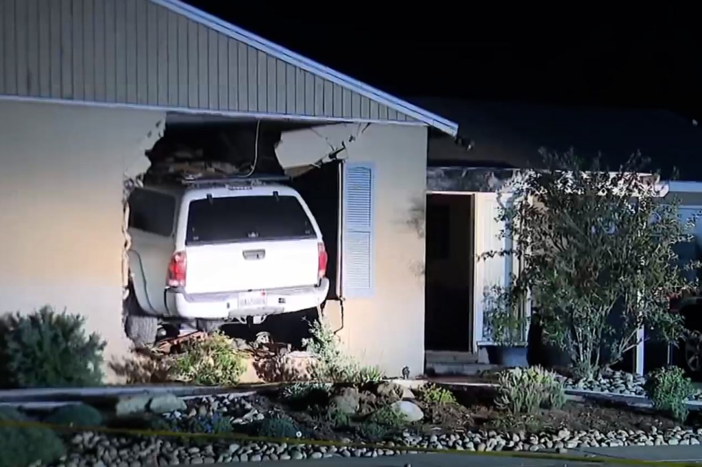 White Toyota Tacoma crashed through the front wall of a house.