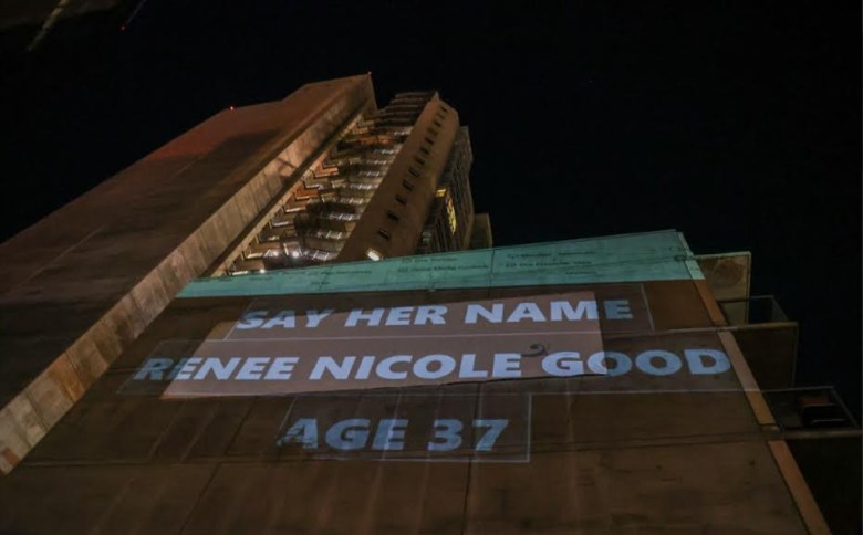 A projection on a downtown building reads "Say Her Name Renee Nicole Good Age 37."