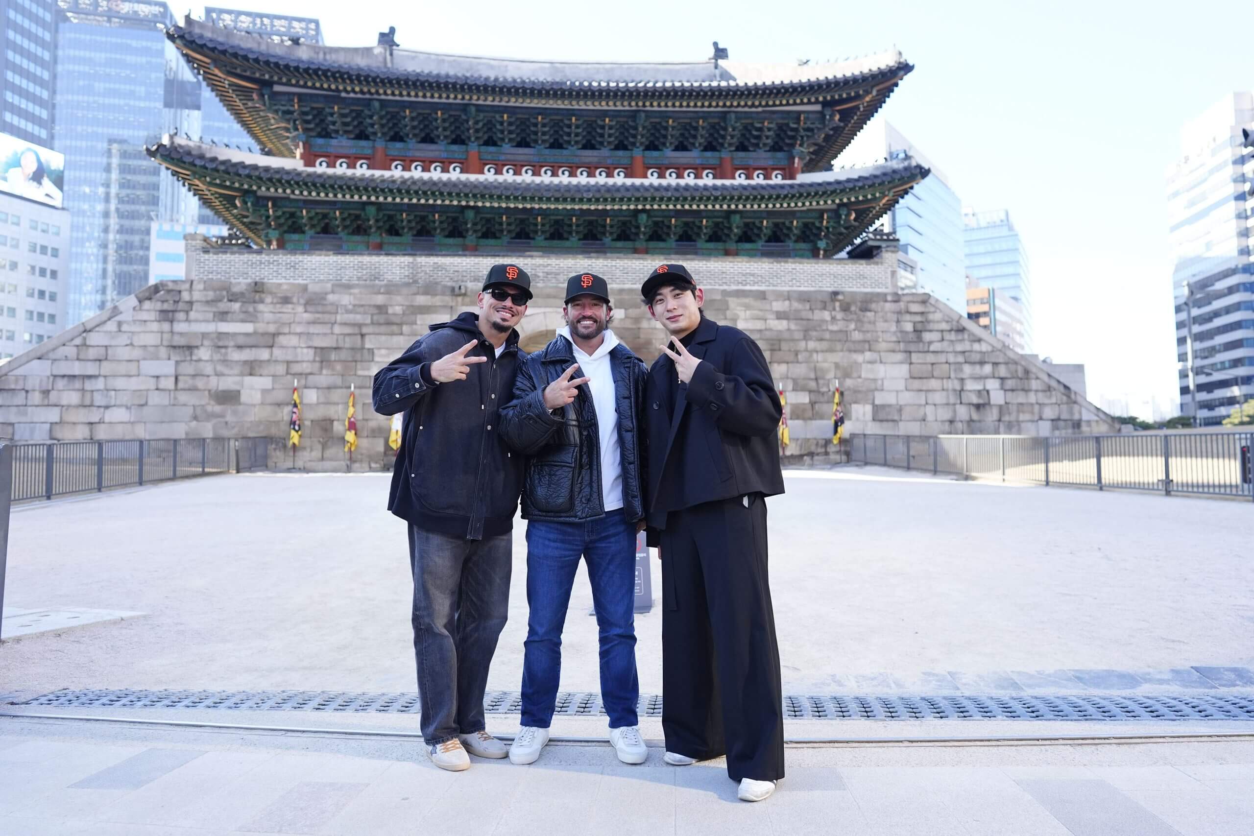 Willy Adames, manager Tony Vitello and Jung Hoo Lee hold up peace signs while posing for a picture at Sungnyemun Gate in Seoul, South Korea.