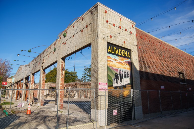 The outer framing of a gray and red bricked building that was burned during a wildfire.