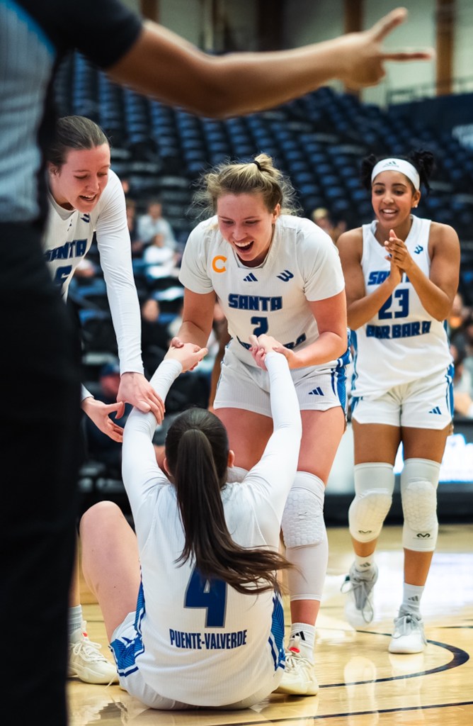 Julia Puente-Valverde (4) is helped up by, from left, Olivia Bradley and Zoe Borter after getting knocked down while scoring a basket on Thursday. Zoe Shaw is at far right.