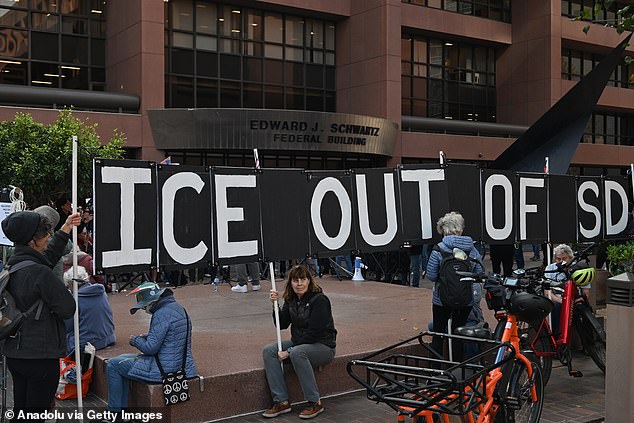 Protesters carry a large sign reading 'ICE out of SD', near San Diego's Edward J. Schwartz Federal Building during a protest against ICE in downtown San Diego, California earlier this month