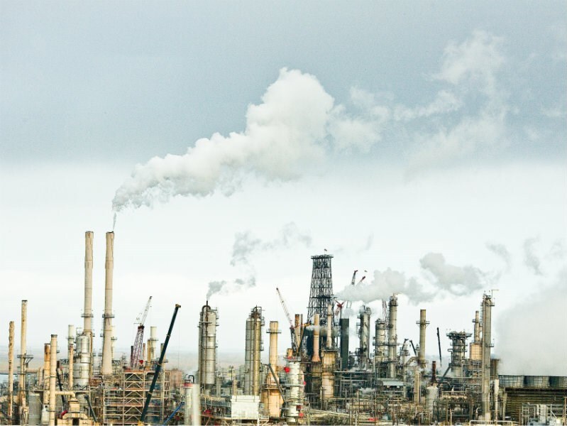 Smoke comes out of pipes from a refinery.