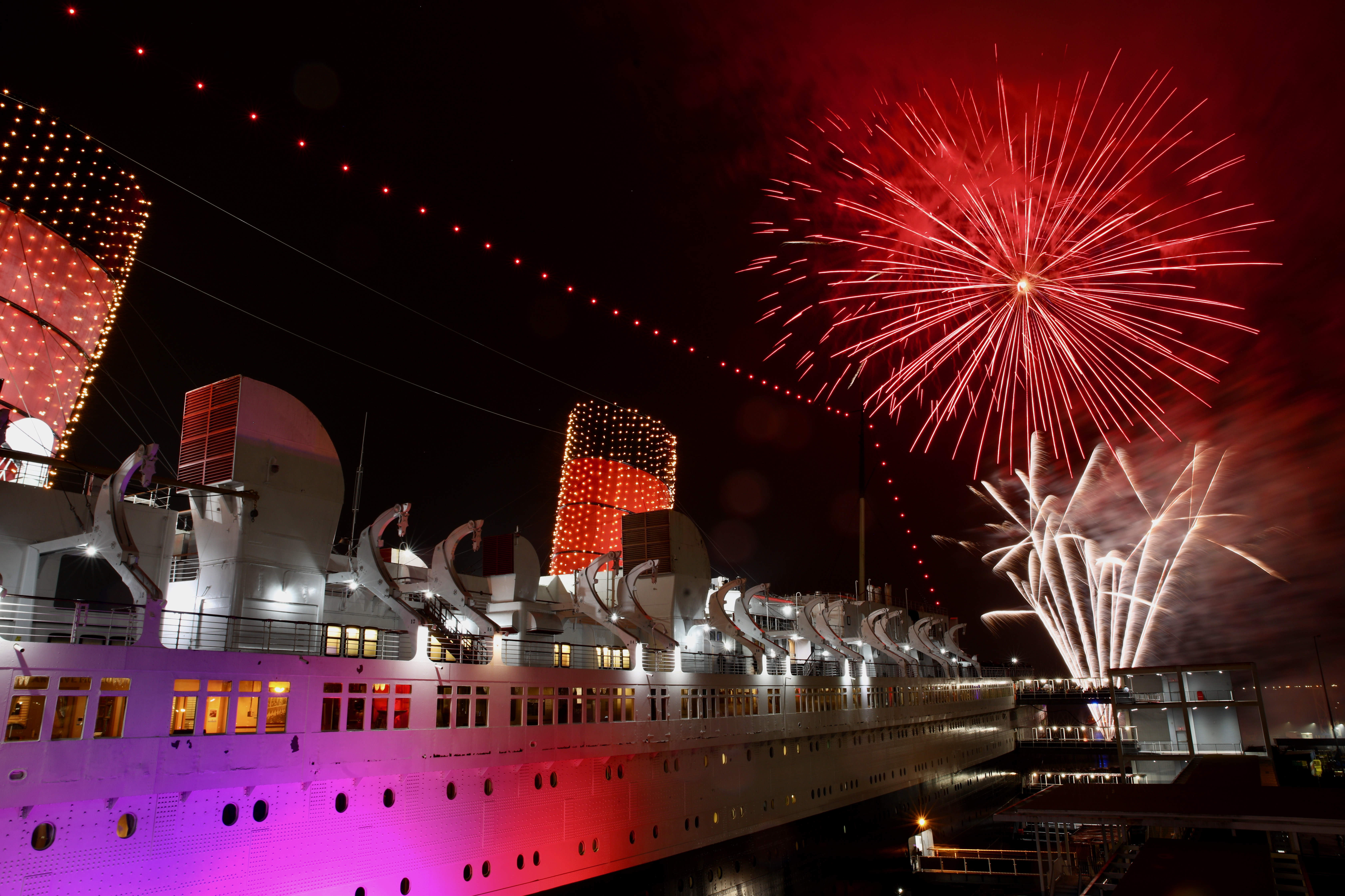 Fireworks light the sky over the stern of the Queen...