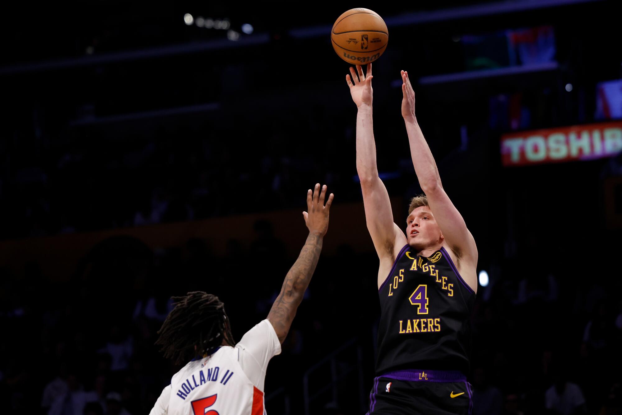 Lakers forward Dalton Knecht extends to shoot the ball while being guarded by Detroit Pistons forward Ronald Holland II.