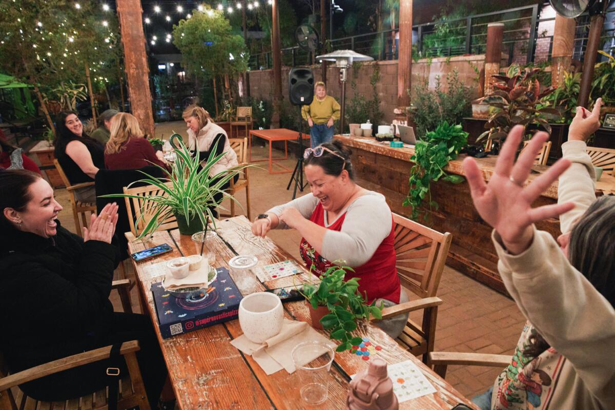 Patricia Steele wins a grand-prize pothos as people play Plant Bingo at Redlands Public Market on Dec. 14.