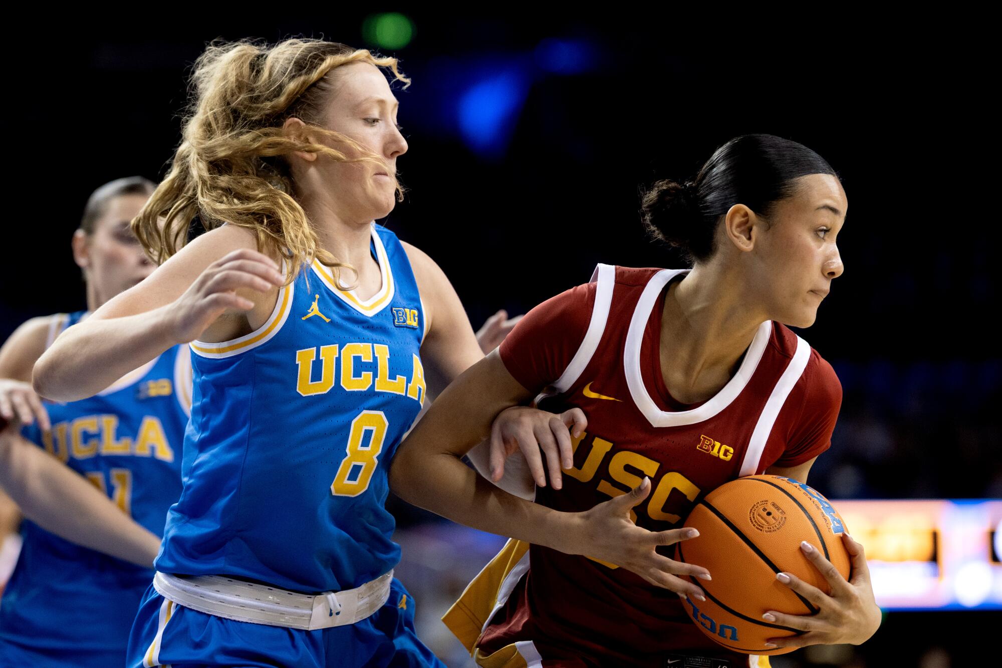 USC guard Jazzy Davidson, right, tries to keep the ball away from UCLA guard Gianna Kneepkens.