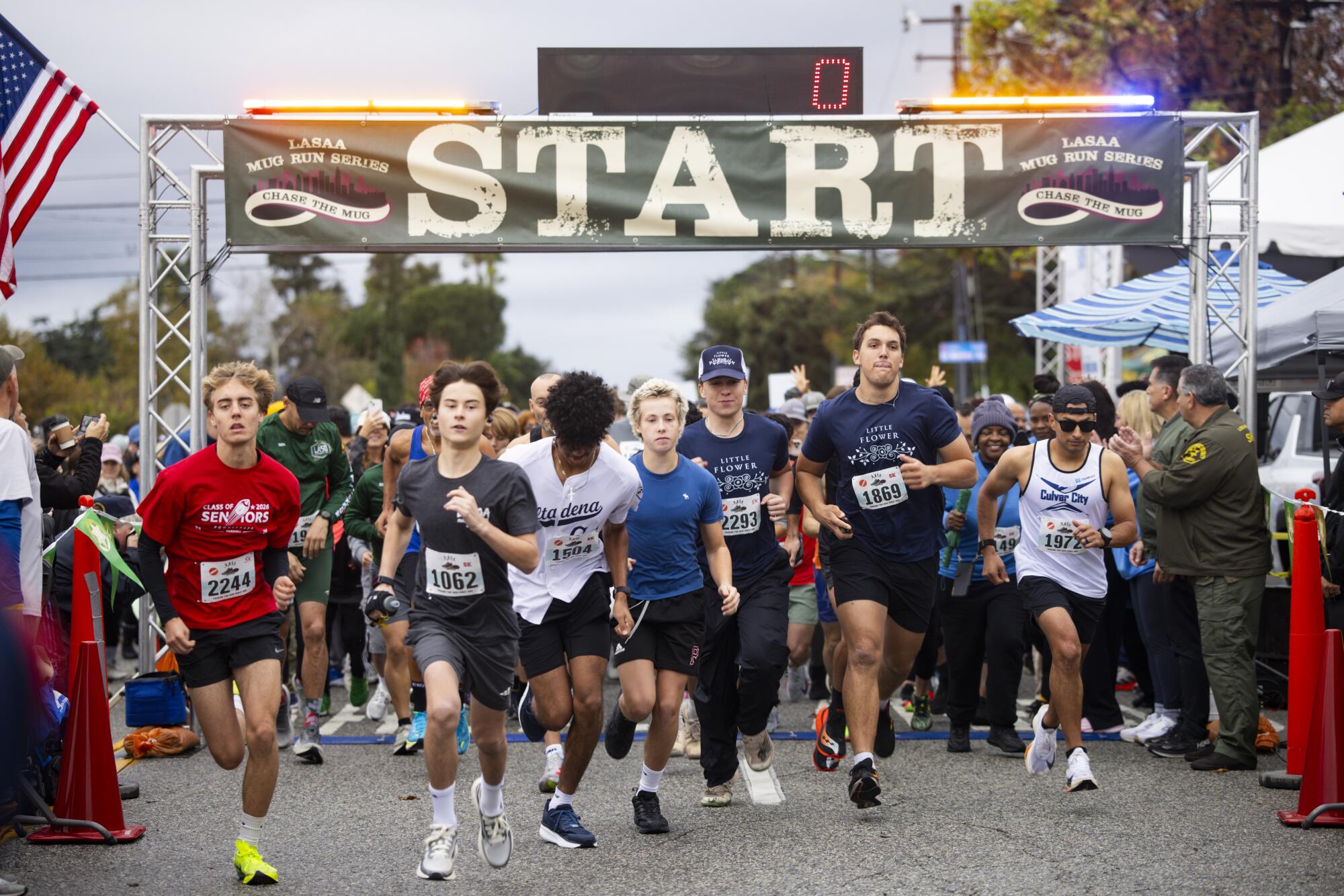 Runners take off at the starting line of a 5K race.
