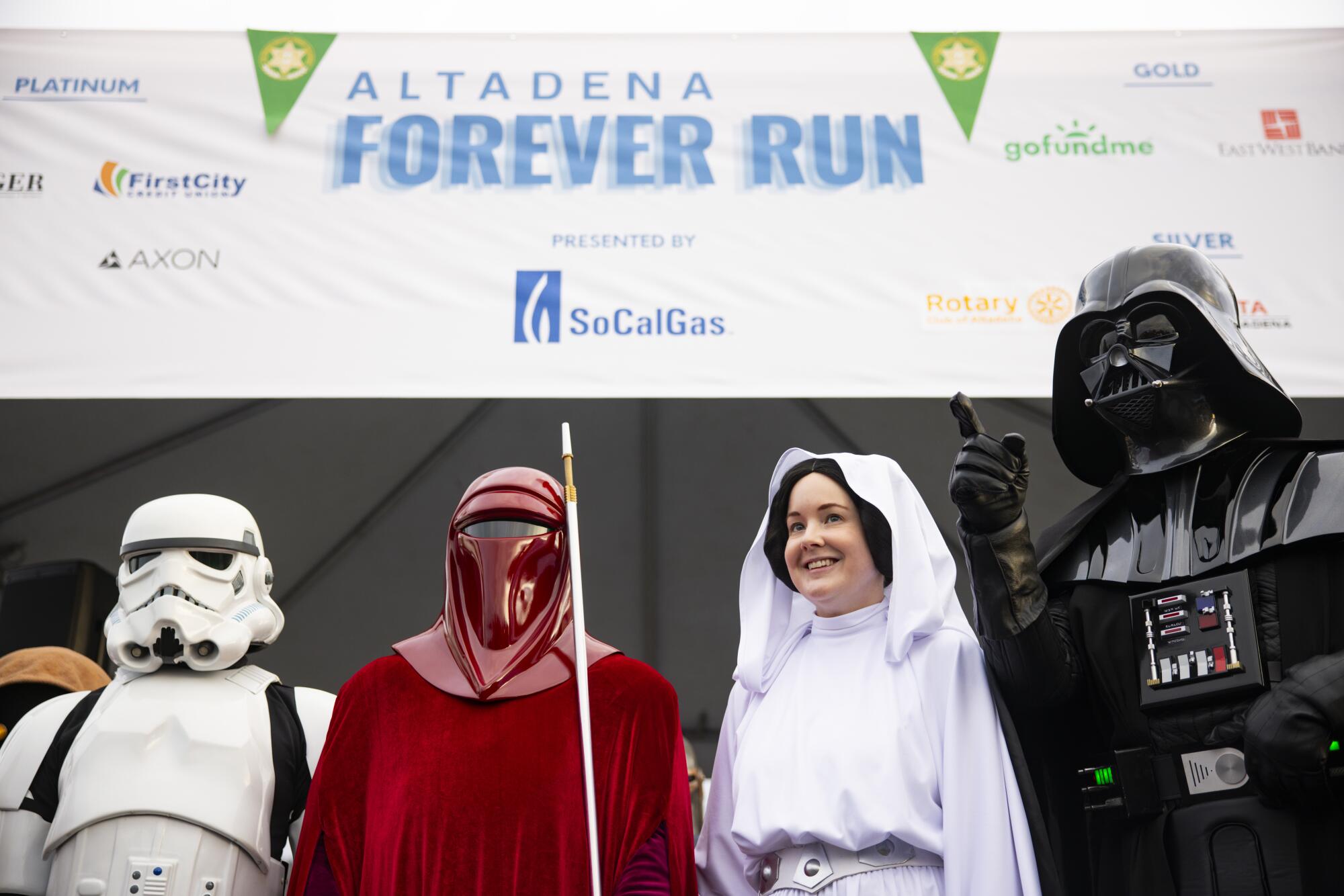 People dressed in Star Wars costumes cheer on the sidelines.