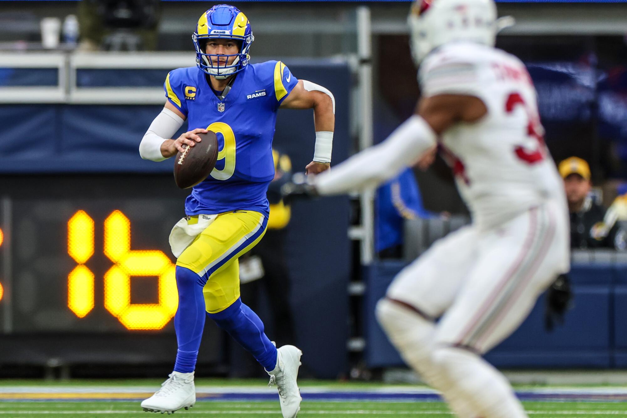 Rams quarterback Matt Stafford rolls out to pass against the Arizona Cardinals at SoFi Stadium Sunday.