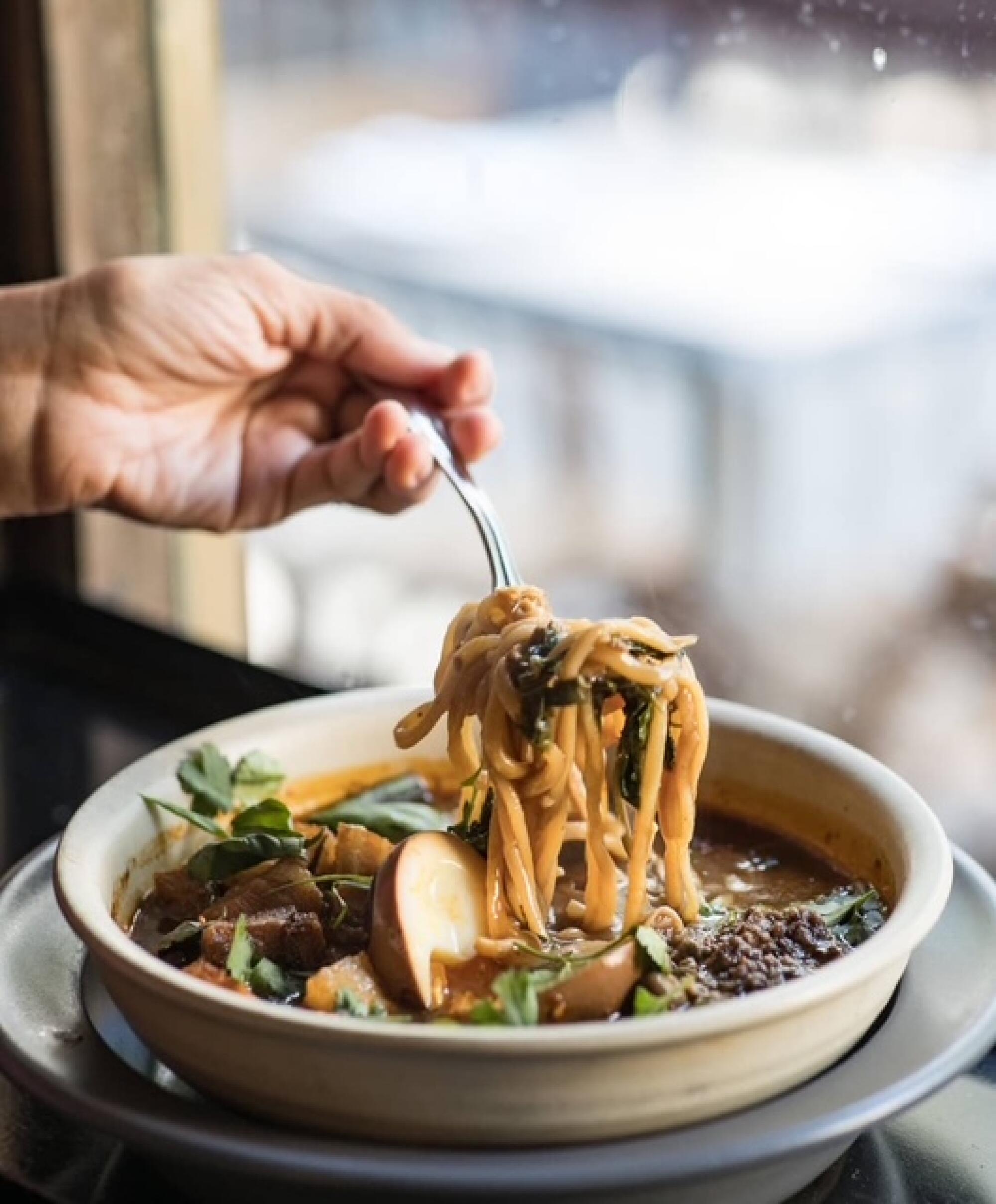 Bäzole with house-made noodles, oxtail, chicken chicharron and harissa shoyu egg from Le Dräq.