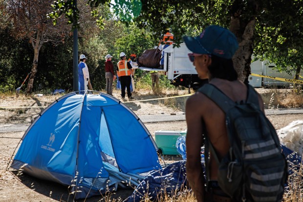 Clean-up crews clear items and trash from a homeless encampment along the Guadalupe River Trail in San Jose, Calif., on Monday, May 19, 2025. (Dai Sugano/Bay Area News Group)