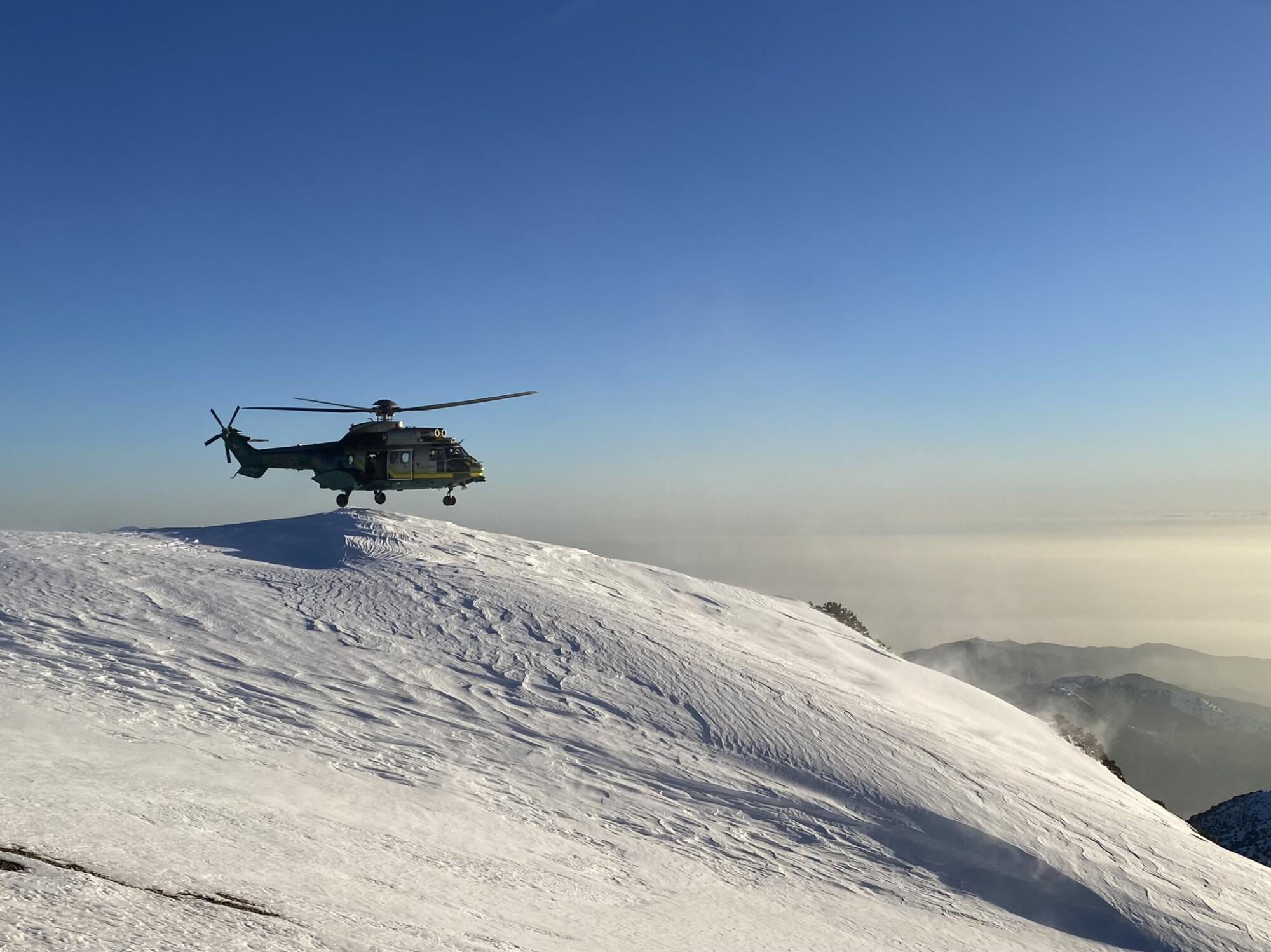 A helicopter on a snow-covered mountain.