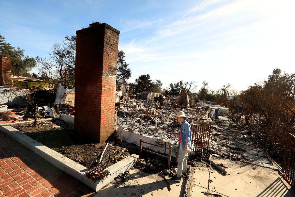 Aimin Li stands in the ruins of her home in Altadena 