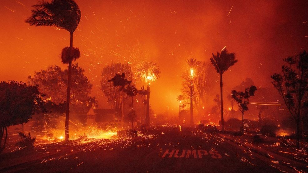 FILE - Embers blow down a street as the Palisades Fire ravages a neighborhood amid high winds in the Pacific Palisades neighborhood of Los Angeles, Jan. 7, 2025. (AP Photo/Ethan Swope, File)