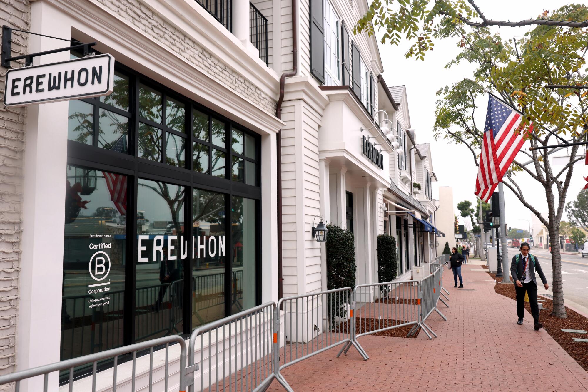 Pedestrians walk past the Erewhon market in Palisades Village that plans to reopen this year.