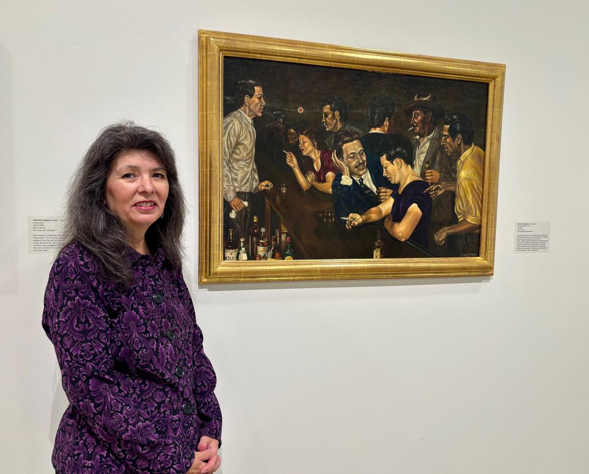 Artist and author Rosemary Vasquez Tuthill, stands with Emigdio Vasquez's work in which she posed as a model.