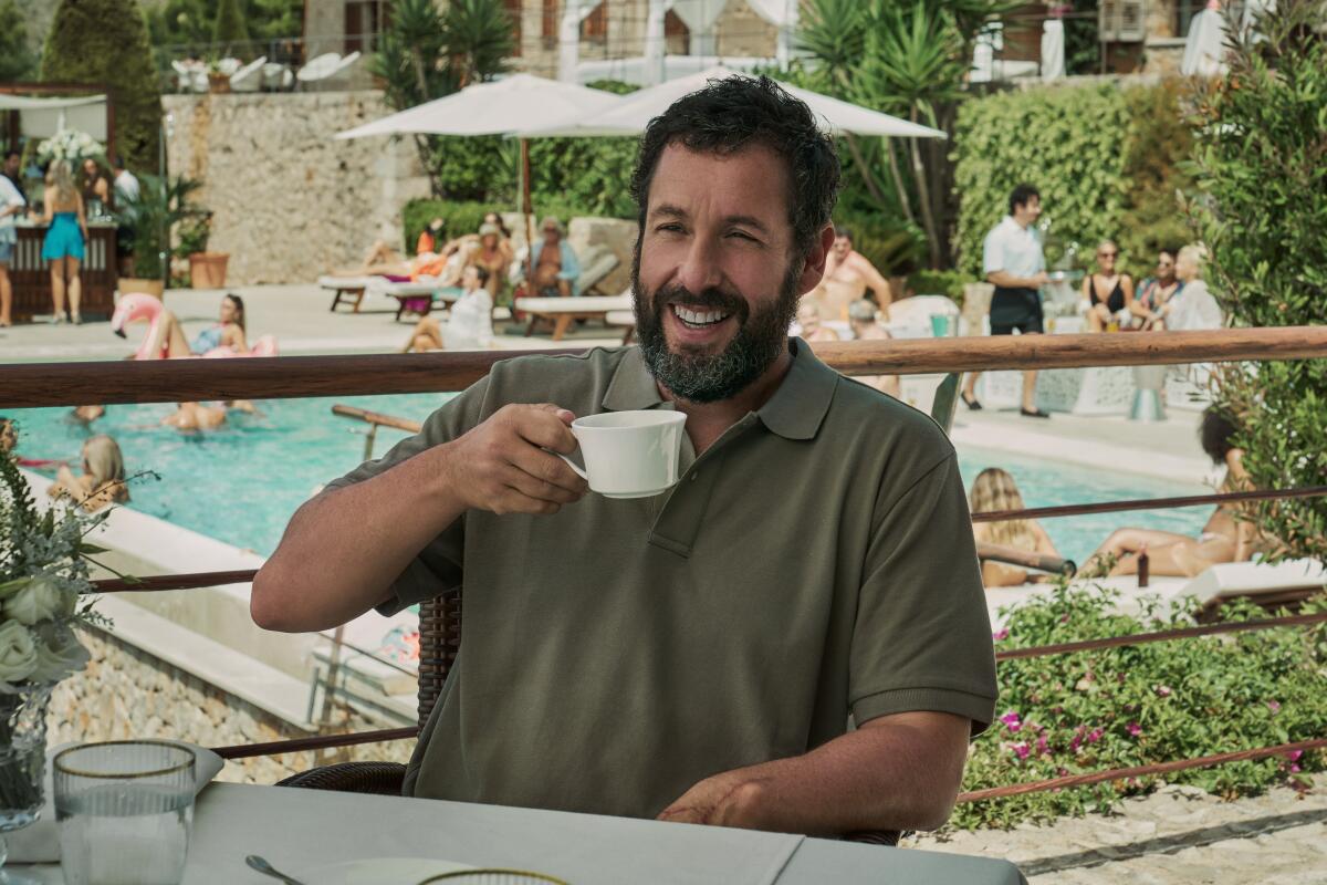A man drinks a cup of coffee poolside.