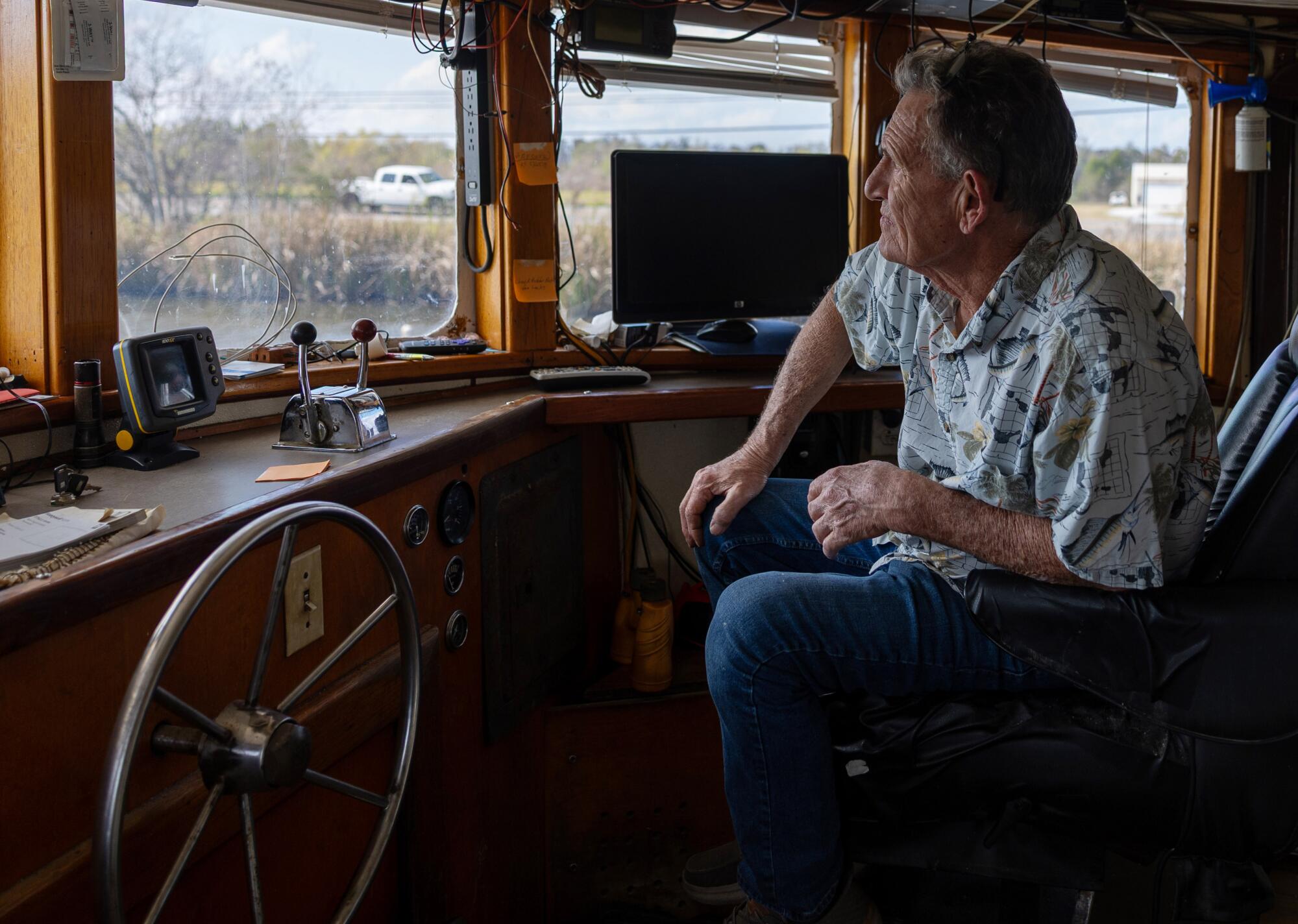 Shrimper James Blanchard sits in the cabin of his fishing boat.