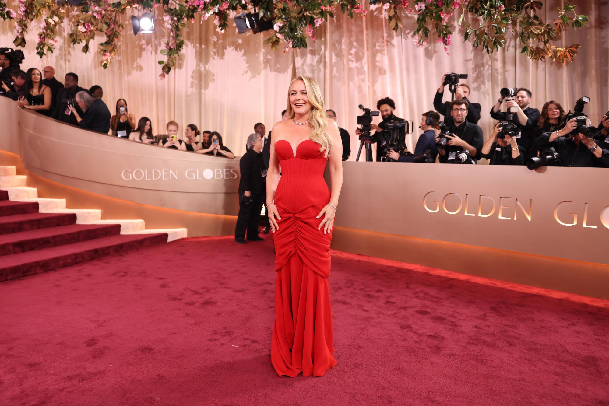 Alicia Silverstone, in a red gown, poses on the red carpet. 