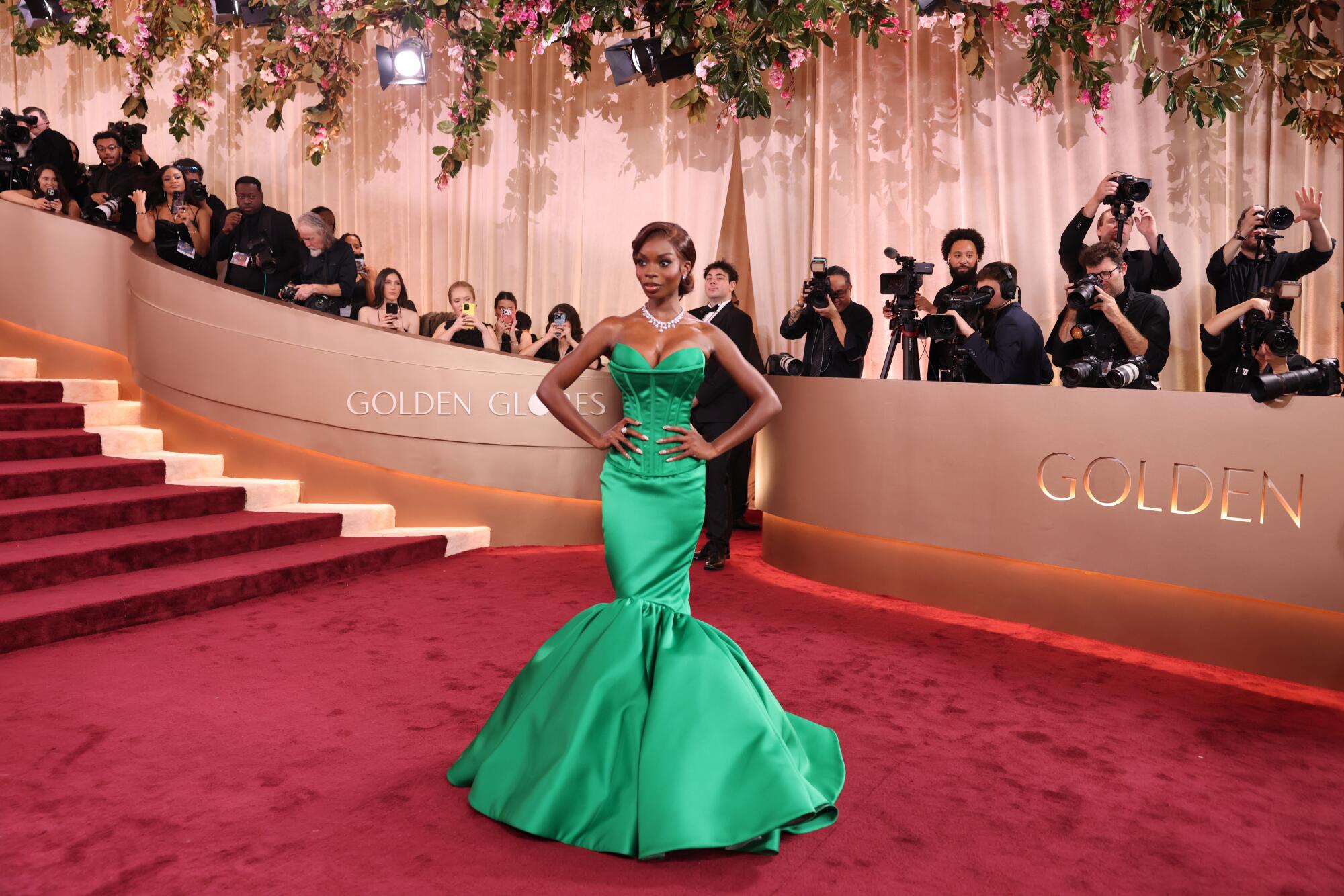Olandria Carthen, in an emerald gown, poses on the red carpet. 