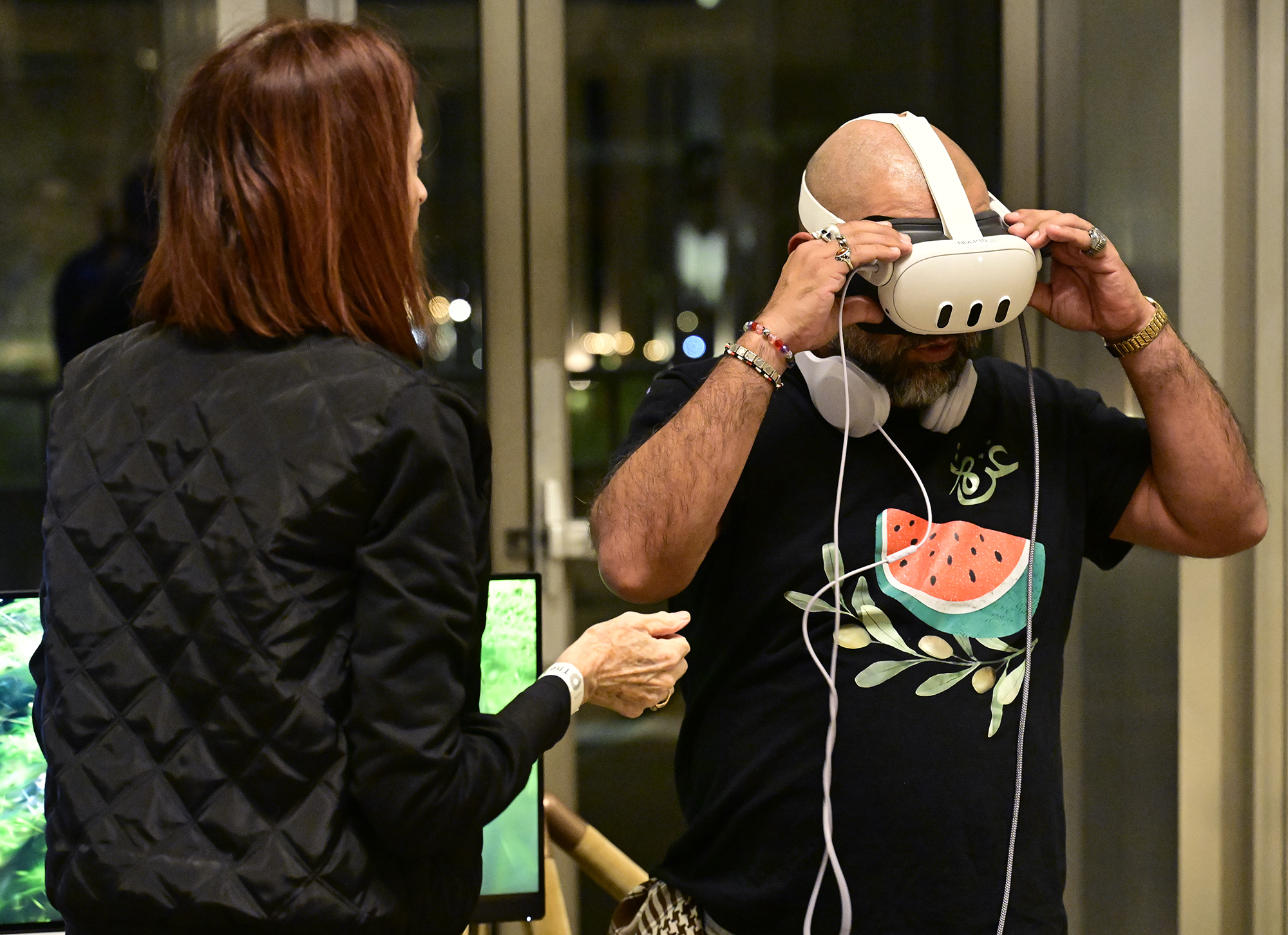 Janet Eckholm assists Carlos Gonzalez as he puts on VR...